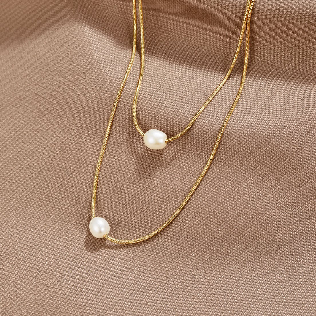 Sabina – Double couche en or avec pendentif en pierre sombre.